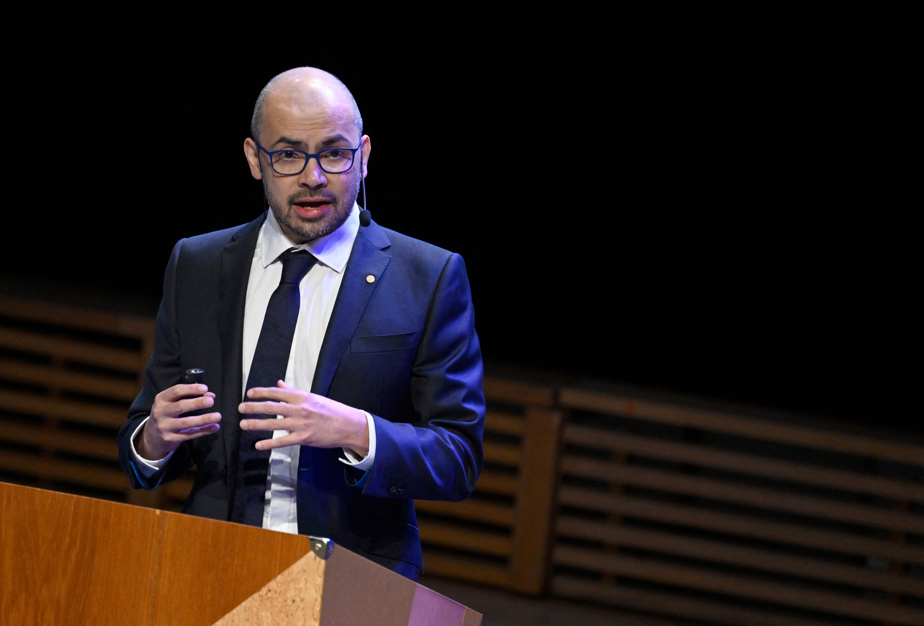 El co-ganador del Premio Nobel de Química 2024, el investigador británico en inteligencia artificial, Demis Hassabis, hace un gesto mientras pronuncia su conferencia del Premio Nobel en el Aula Magna de la Universidad de Estocolmo, Suecia, el 8 de diciembre de 2024. (Foto AFP)