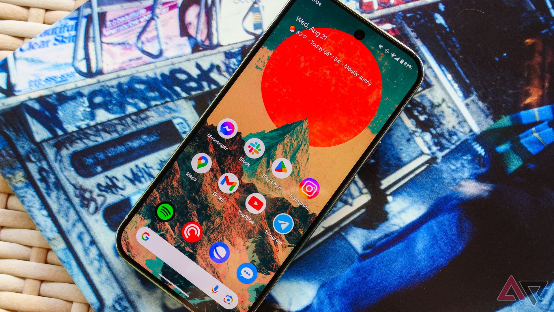 El Pixel 9 Pro en una mesa de mimbre y yacía encima de una funda de álbum con la pantalla arriba