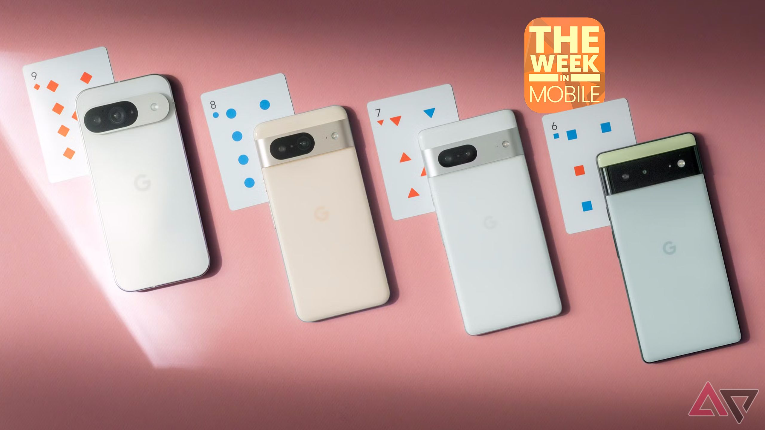 Cuatro teléfonos Google Pixel dispuestos en una superficie rosa junto a las cartas de juego