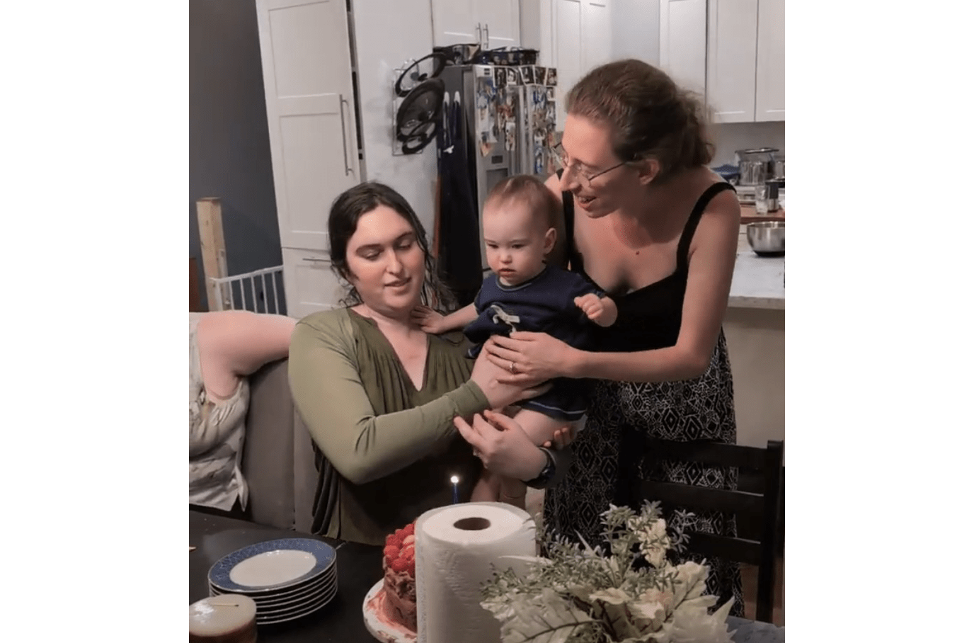 Two women holding their baby for a first birthday