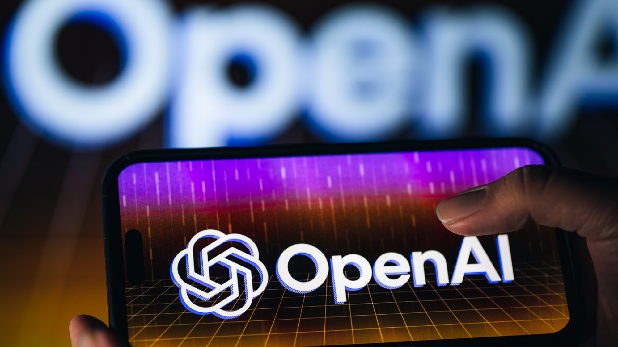 Persona que sostiene el teléfono inteligente con el logotipo de OpenAI en la pantalla